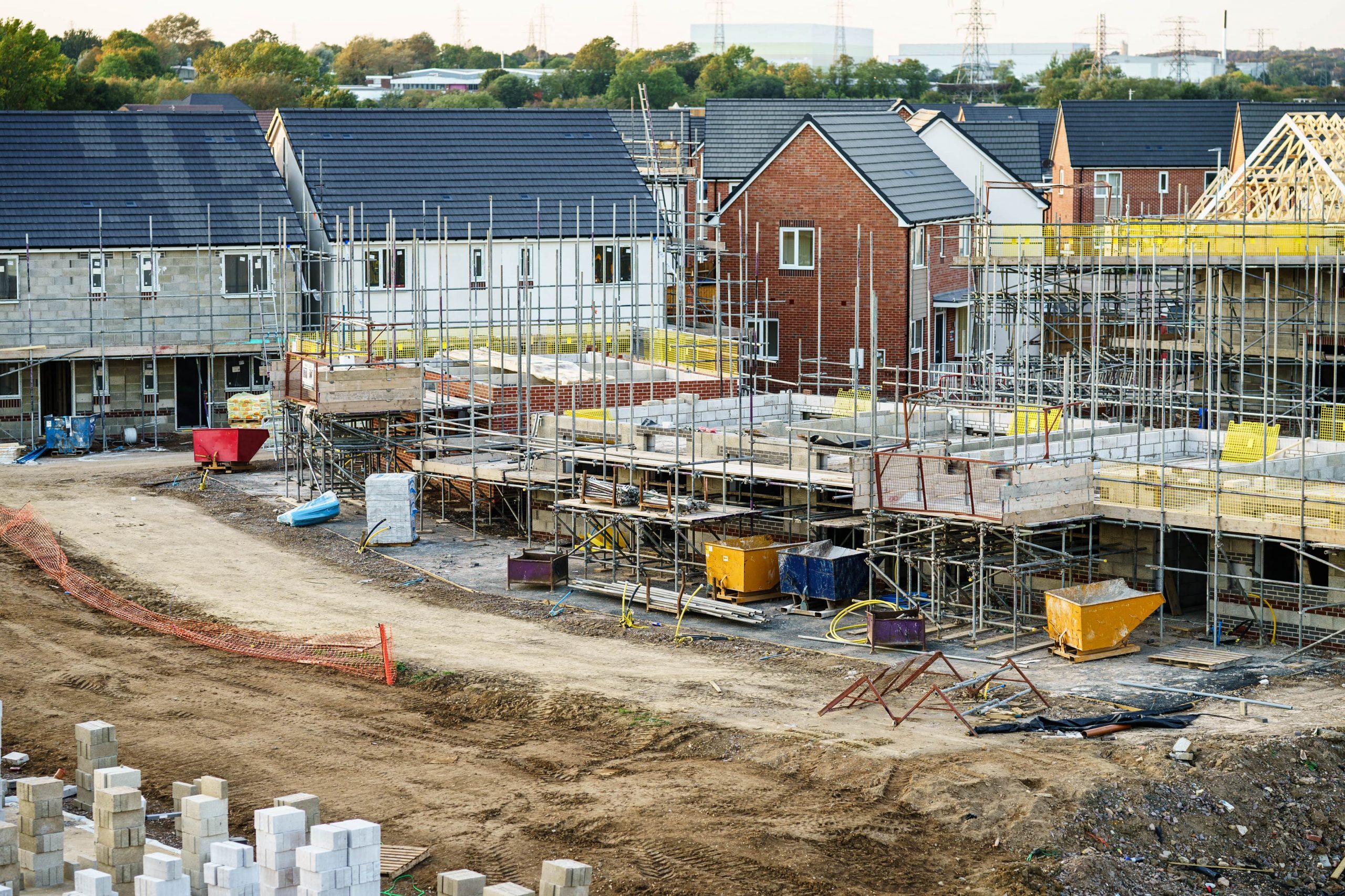 ShowEquip covers the Construction sector / industry. Image of building site with scaffolding around a part built house with externally completed buildings behind.